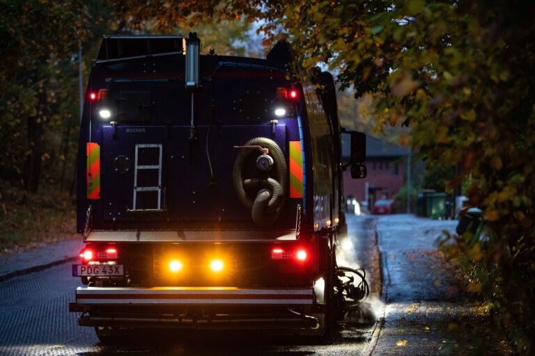 Sandupptagning i villaområde under kvällstid med gatubelysning