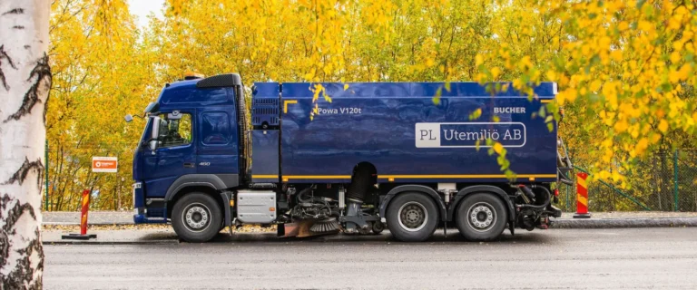 Sopmaskin i arbete under höstdag – lövsopning på asfalterad yta för en ren och säker utemiljö.
