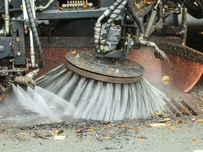 Gatusopning - höst städning av gata sopar upp löv och tvättar vägen