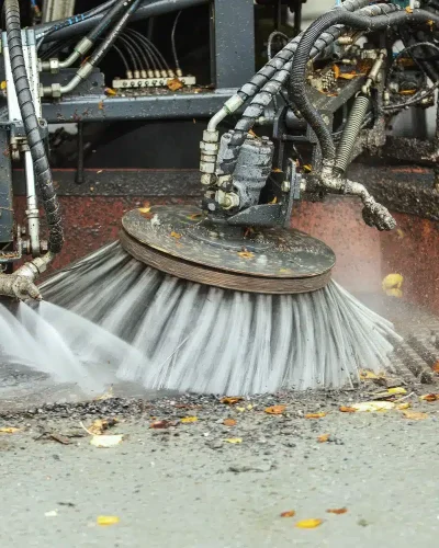 Gatusopning - höst städning av gata sopar upp löv och tvättar vägen